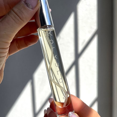 A close-up of a bottle of Korkunova Vanilla Dream pheromone perfume being held up to the camera